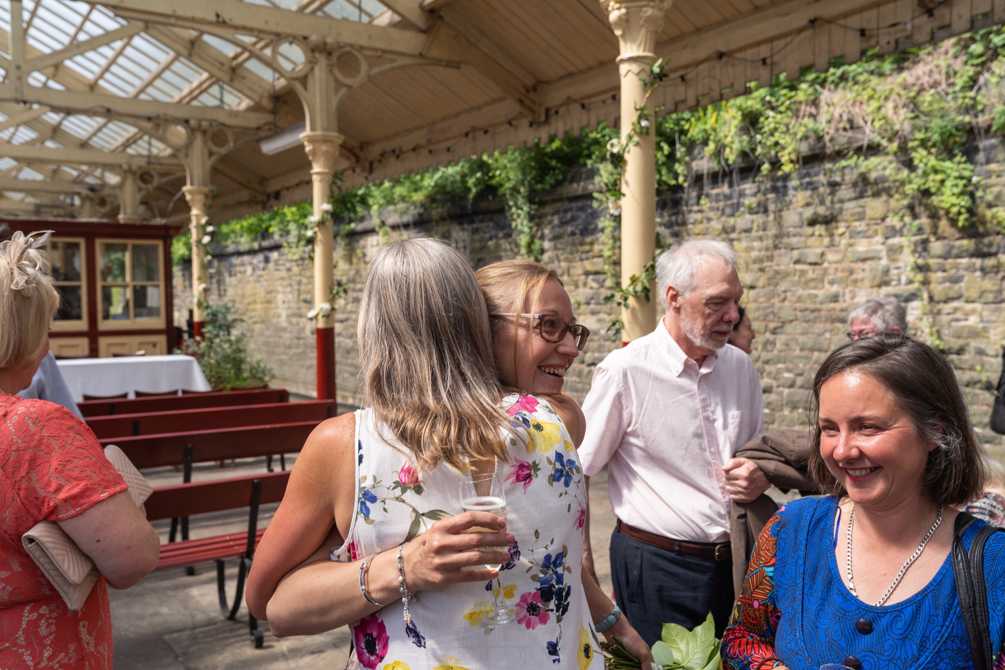 Guests chatting and holding drinks under the station canopy after the ceremony