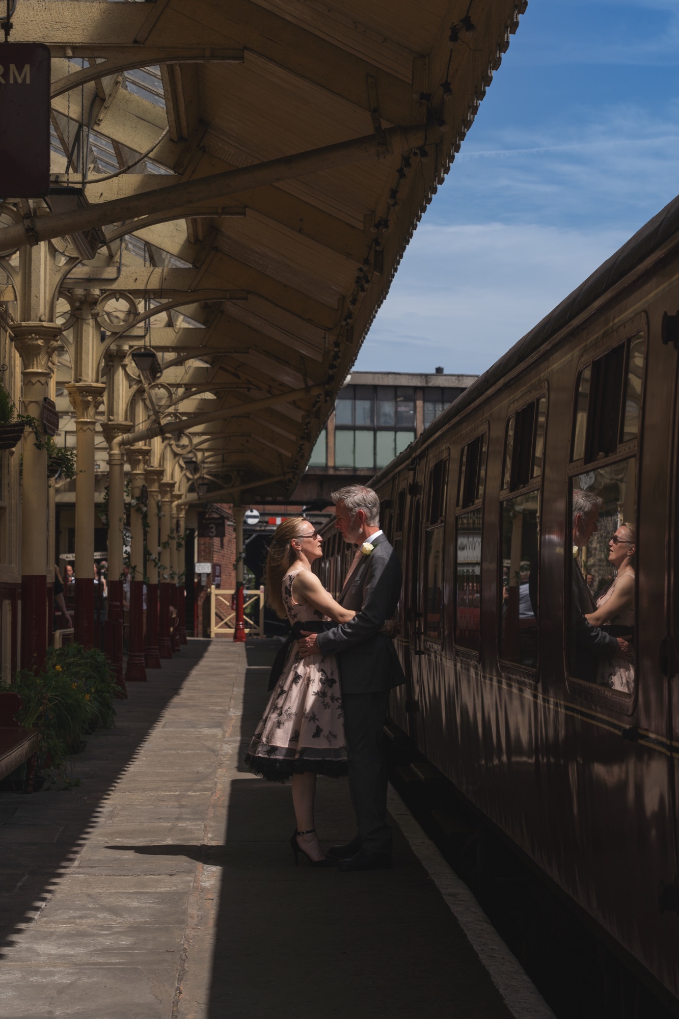 Bride and groom kissing on the platform beneath the Platform 4 sign