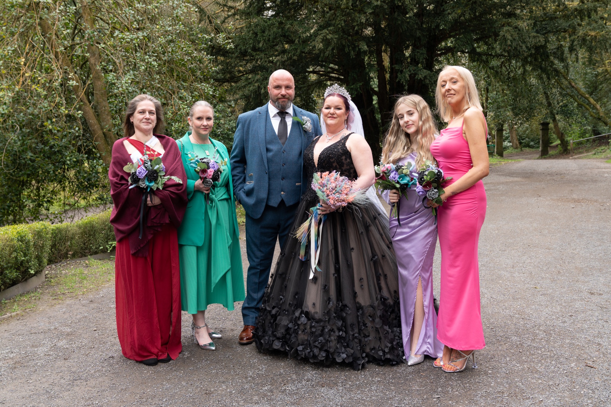 The bride and groom pose with the bridal party in the woodland grounds of Sunnyhurst Wood.