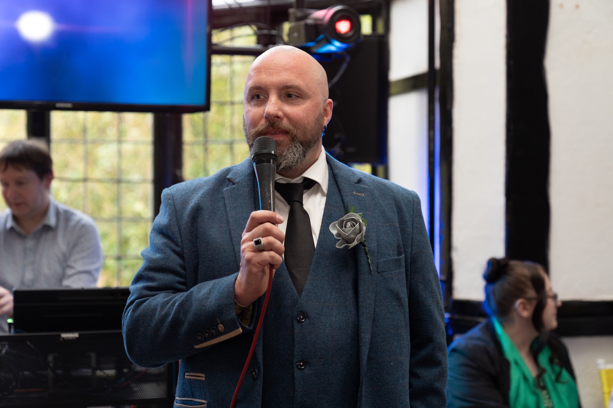The groom speaks into a microphone during the reception speeches.