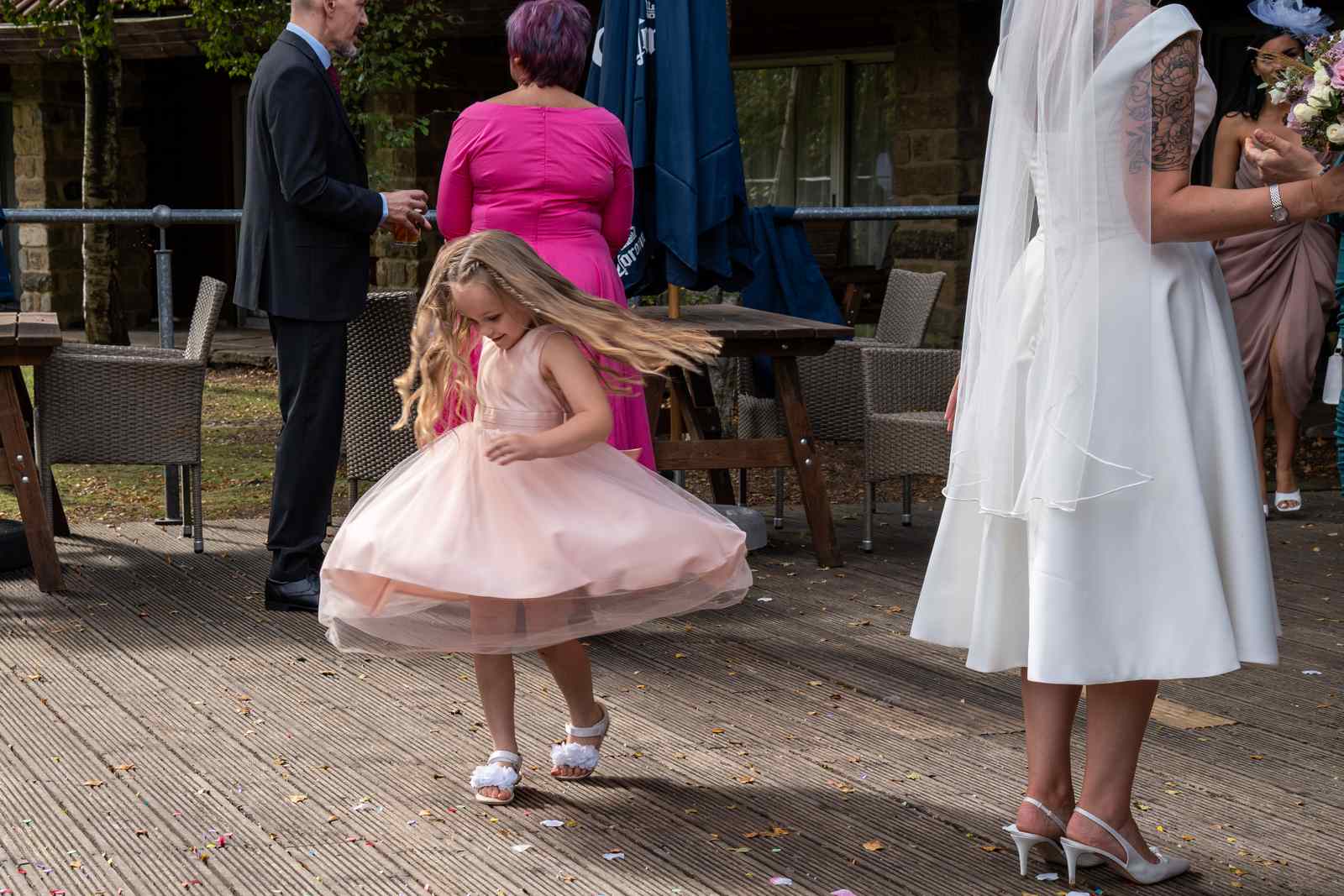 A flower girl twirling in her dress at Chris and Mandy's wedding