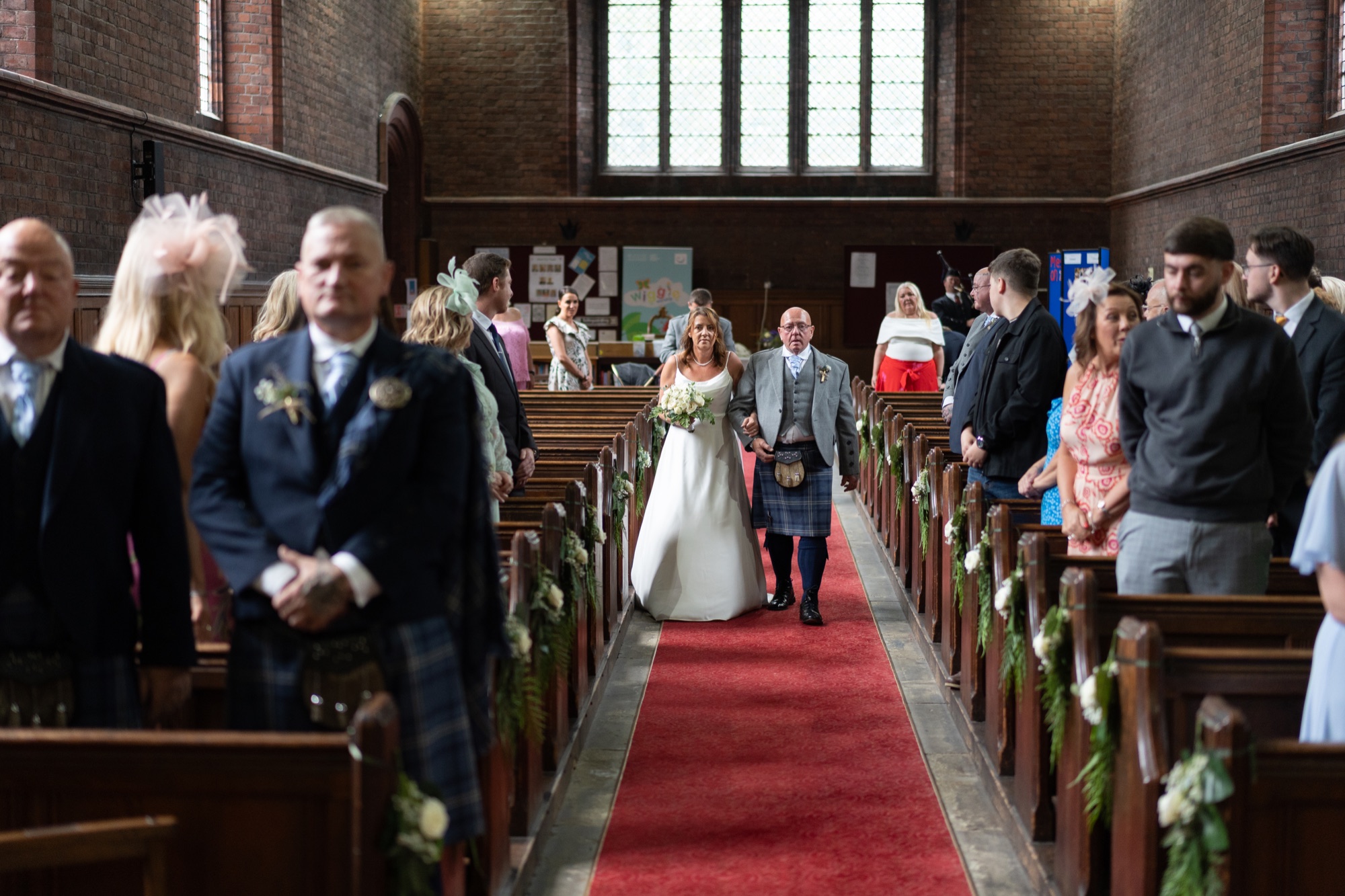 Bride walking down the church aisle on her father's arm