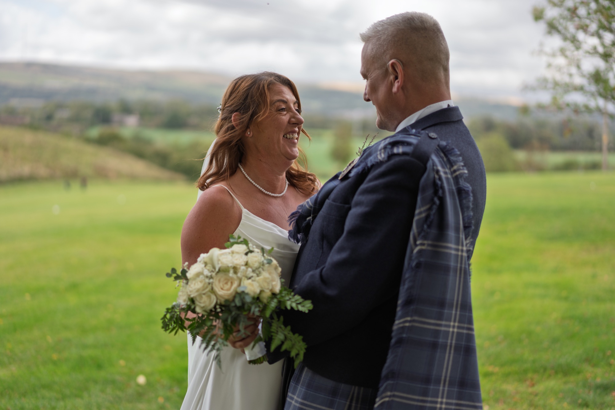 Bride and groom portrait framed by overhanging tree branches