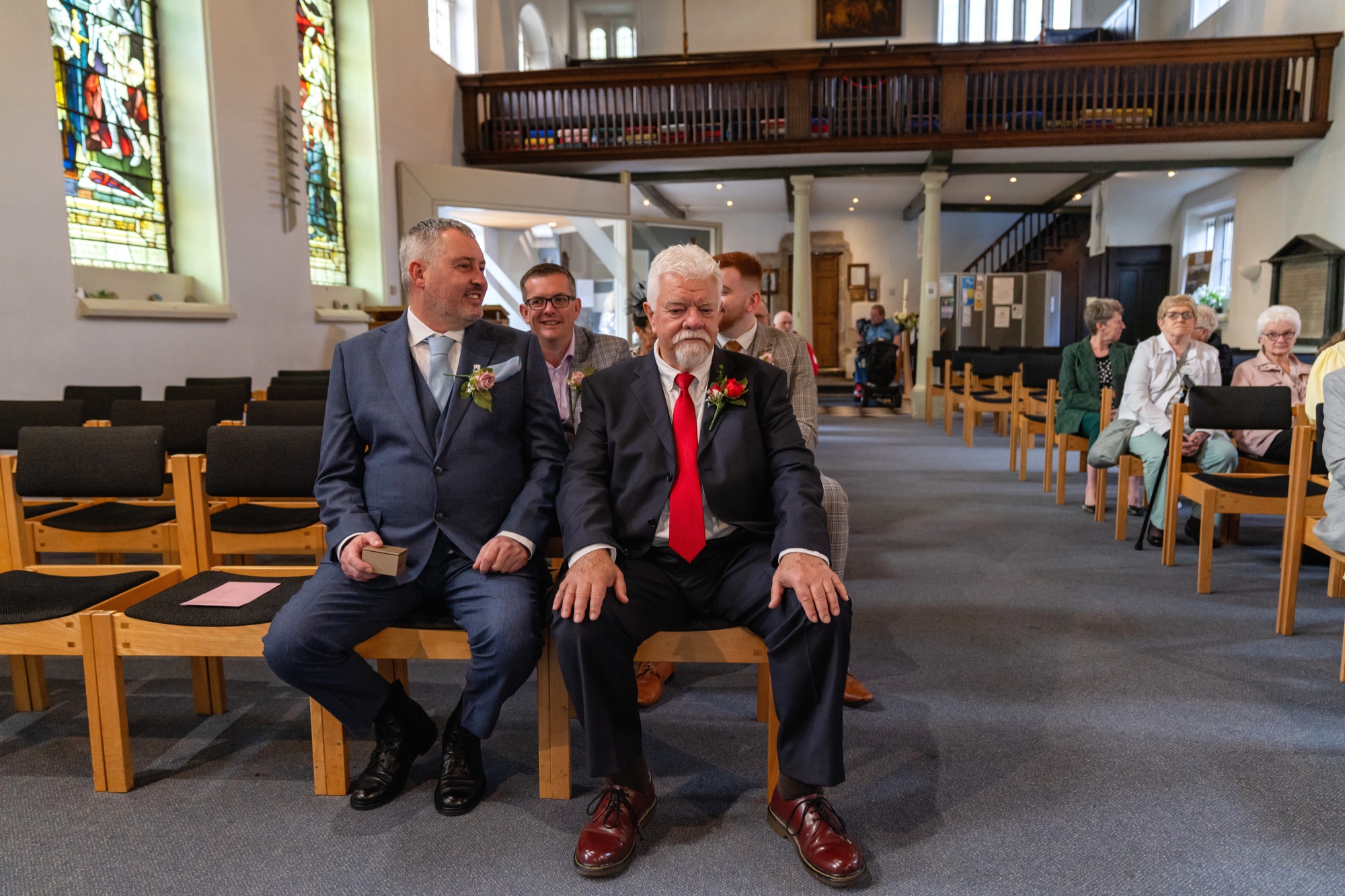 The groom sitting with a groomsman inside St Mary's Church before the ceremony begins
