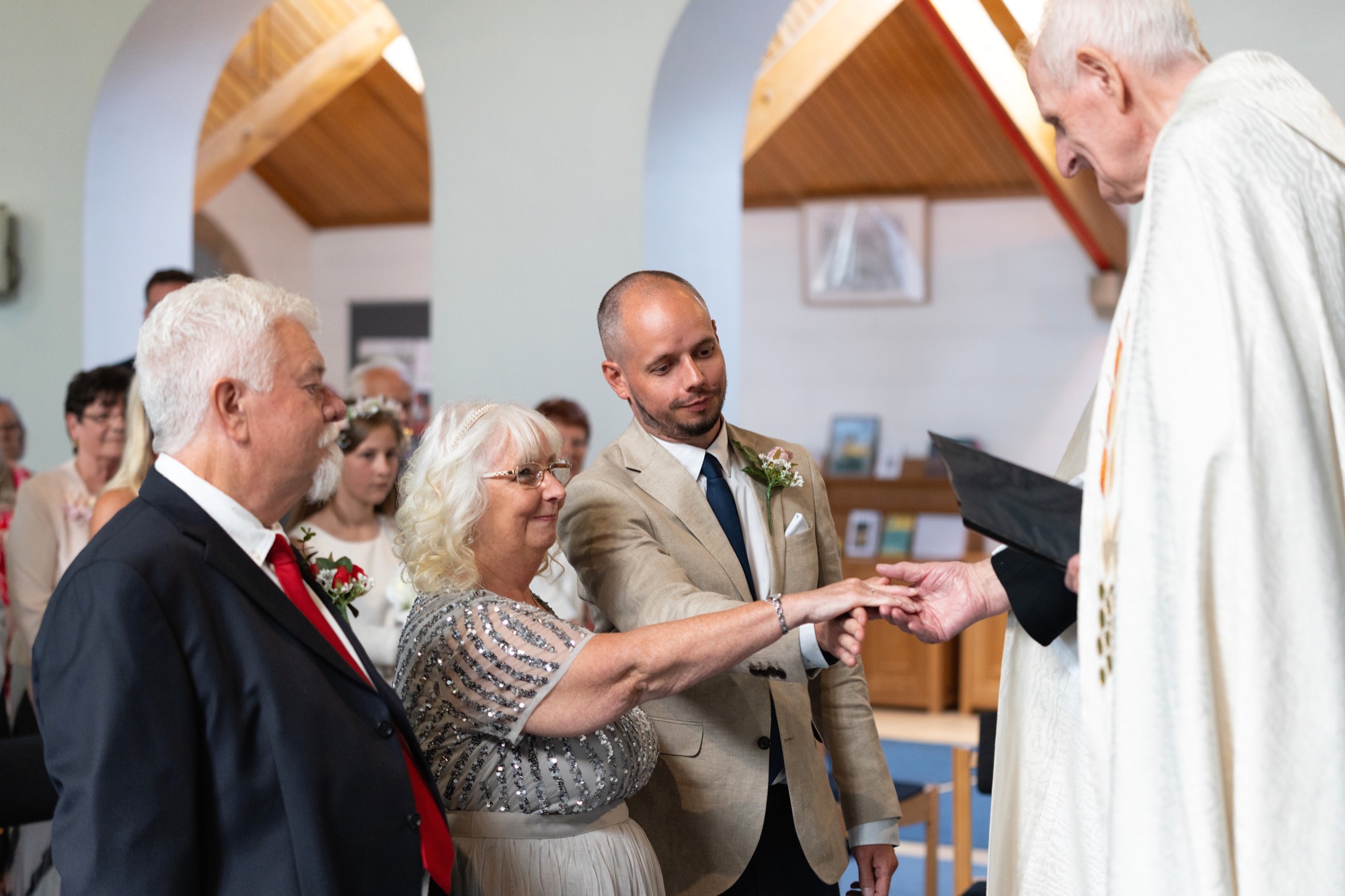 The bride, groom and family gathered at the altar as the register is signed