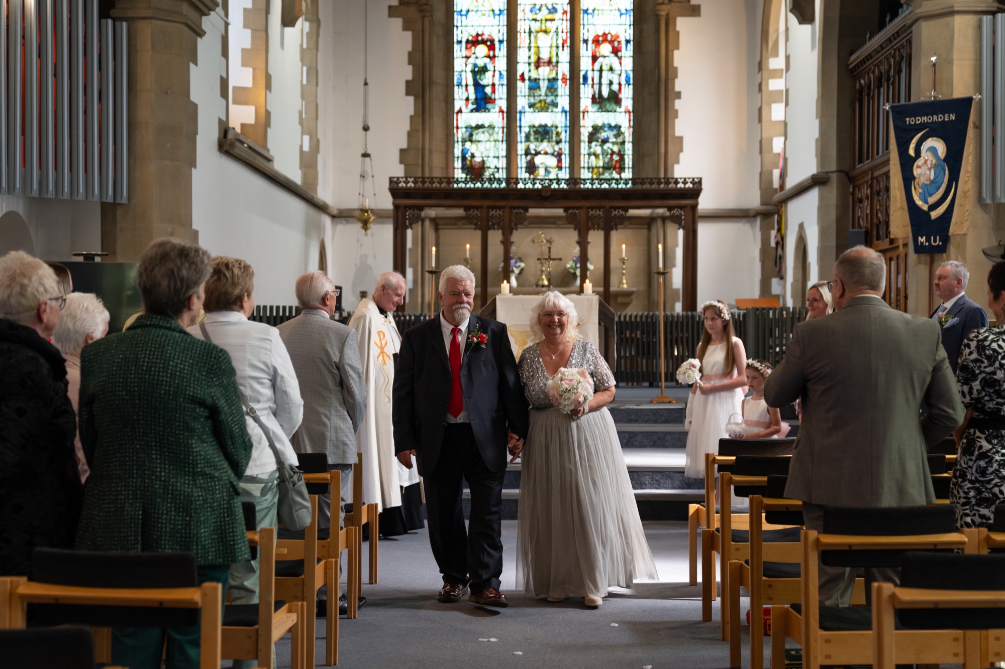 The newly married couple walking hand in hand back down the aisle