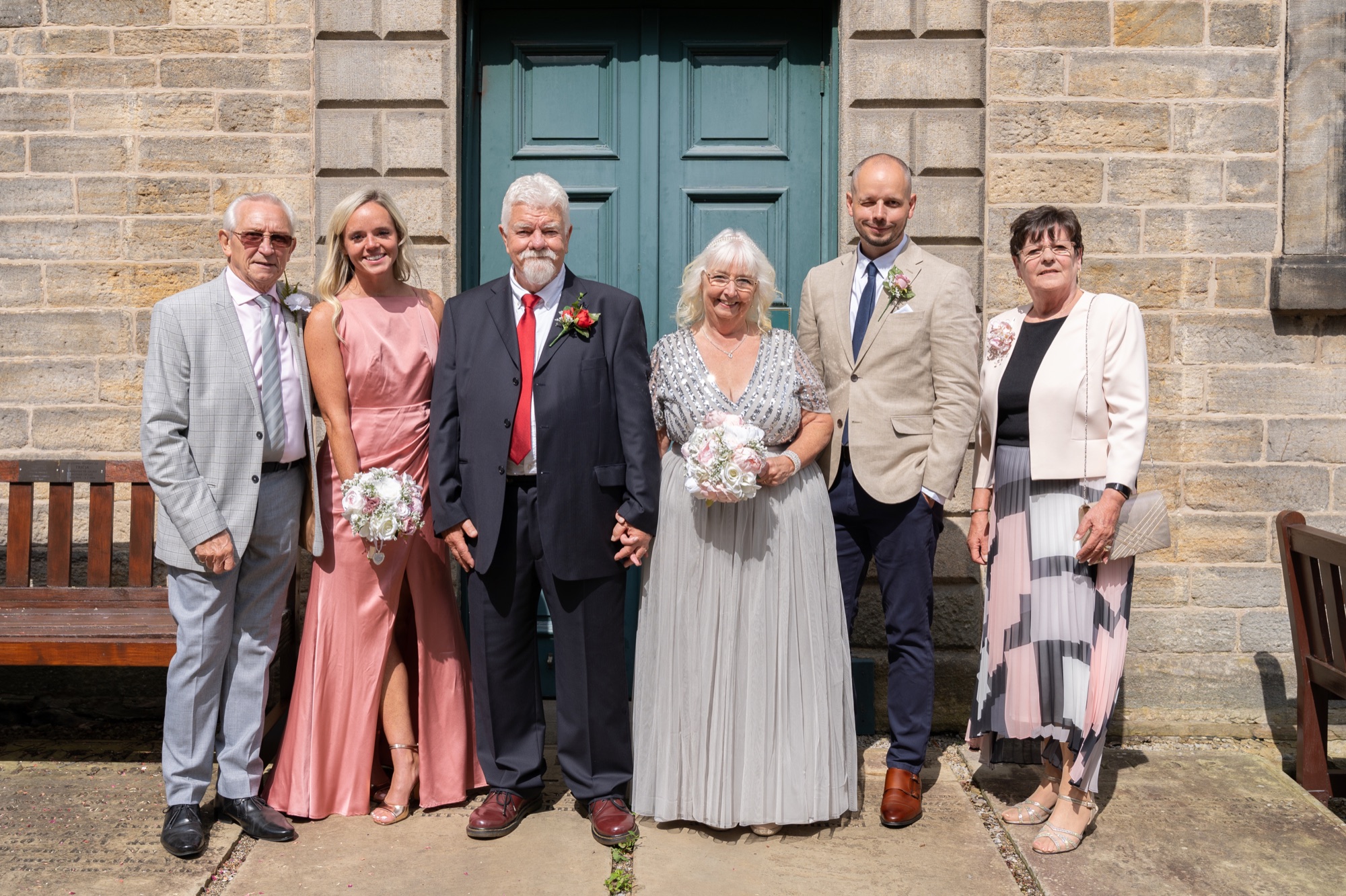 The bride, groom and family posing for a group photograph outside the church